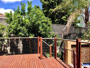een houten terras met een hek en bomen bij Cloud 9 Guest Suite in Burwood East