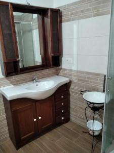 y baño con lavabo y espejo. en Sa Domu de Ladiri GuestHouse 2.0, en Musei