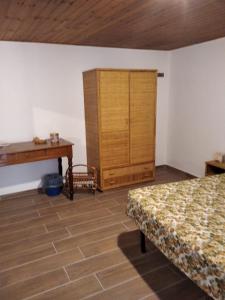 1 dormitorio con 1 cama, armario y escritorio en Sa Domu de Ladiri GuestHouse 2.0, en Musei