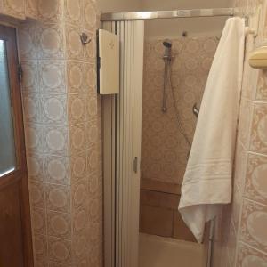 een badkamer met een douche en een witte handdoek bij Casa via Garibaldi in Lanciano