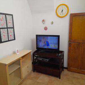 een woonkamer met een tv op een tafel en een klok bij Casa via Garibaldi in Lanciano