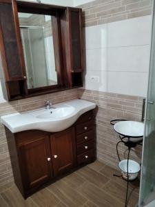 y baño con lavabo y espejo. en Sa Domu de Ladiri GuestHouse 2.0, en Musei
