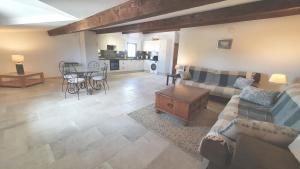 a living room with a couch and a table at 'Au Coeur des Vignes' - private apartment & garden in Magalas