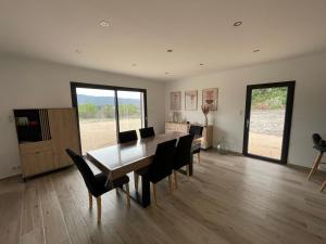 a dining room with a table and black chairs at Maison vacance caseneuve in Caseneuve