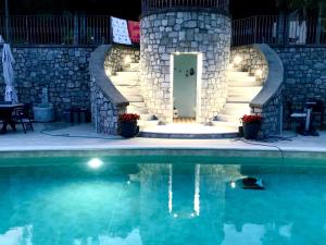 a house with a swimming pool at night with a stone wall at Il Bacio del sole in Lovere