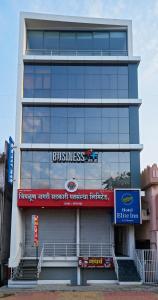 un edificio alto con un cartel en el costado en Hotel Elite Inn- In Front Of Railway Station, en Kolhapur