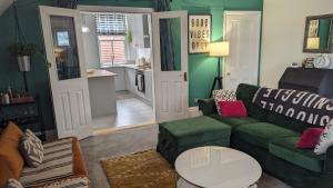 a living room with a green couch and a table at City Boho Loft Apartment Free Parking in Brighton & Hove
