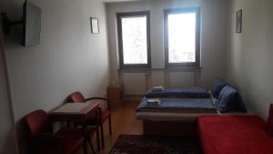 um quarto com uma cama, uma mesa e duas janelas em Privát Viktória Terchová em Terchová