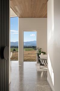 a dining room with a view of a field through a glass door at Tiffin Hill in Parkvale