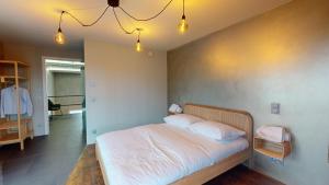 una camera da letto con un letto con lenzuola bianche e due cuscini di The Sunset Club - LOFT - 155 m2 Sichtbeton - Zentral a Memmingen