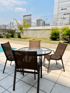 una mesa de cristal y sillas en un patio en LK Barro Preto 8, en Belo Horizonte