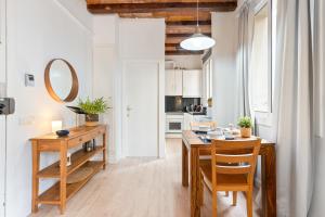 una cucina e una sala da pranzo con tavolo e sedie in legno di Lodging Apartments Barceloneta Beach Studio 12 a Barcellona