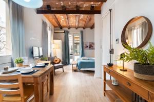 una sala da pranzo e un soggiorno con tavolo e specchio di Lodging Apartments Barceloneta Beach Studio 12 a Barcellona