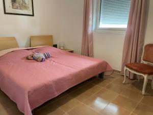 1 dormitorio con 1 cama rosa y 2 zapatillas en Casa Rosa, en Mattinata
