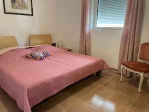a bedroom with a pink bed with two slippers on it at Casa Rosa in Mattinata