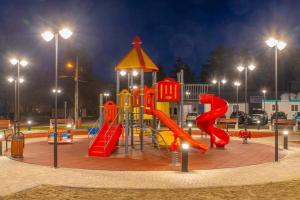 a playground with a slide in a park at night at Ady & Marcy in Onești