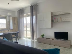 a living room with a couch and a table and a television at Sole, mare e trallallà in Rilievo