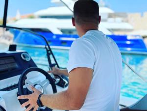 a man driving a boat in the water at Apartment Rovci 2 in Slatine