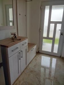 uma cozinha com armários brancos e uma grande janela em Tina em Pula