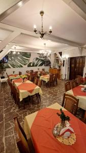 a restaurant with tables and chairs and a chandelier at Zajazd-restauracja Zyga in Iwkowa +46 photos