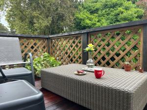 a wicker table with a vase of flowers on a deck at Rest & Relax villa Whangarei 4 Bedrooms 2 Bath family home in Whangarei
