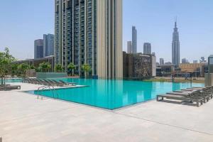 duży basen z krzesłami i panoramą miasta w obiekcie Golden Glitter 1 Bedroom in Downtown Dubai w Dubaju
