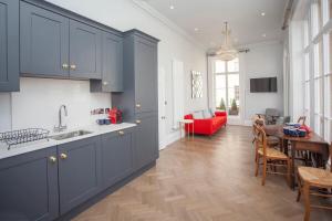 a kitchen with blue cabinets and a dining room at Beautiful City Centre Apartment - Bath in Bath