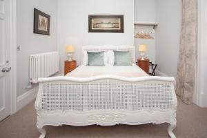 a white bedroom with a white bed and two lamps at Beautiful City Centre Apartment - Bath in Bath