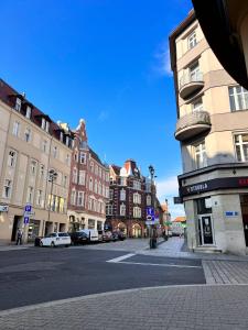 a city street with buildings and cars on the street at Gliwice on a budget 90m from the main square in Gliwice