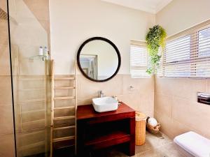 a bathroom with a sink and a mirror at 4 Bedroom Home, St Francis Links Golf Estate in St Francis Bay