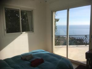 een slaapkamer met een bed en een grote glazen schuifdeur bij Villa with DREAM VIEW and SWIMMING POOL!! in Les Issambres