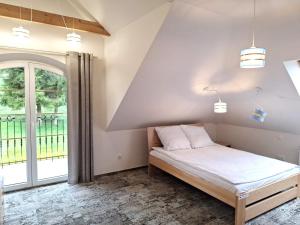 una camera con letto e finestra di Windmill Resort Agroturystyka a Mucharz