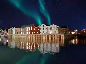 a city with the aurora in the sky over the water at Henningsv&aelig;r Bryggehotell - by Classic Norway Hotels in Henningsv&aelig;r