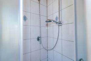a shower with a shower head in a bathroom at B&B Vransko 29 in Vransko