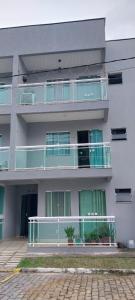 un edificio de apartamentos con balcones verdes y blancos en CONDOMINIO RECANTO DO MAR II, en Rio das Ostras