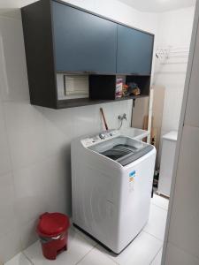 una pequeña cocina con fregadero y lavadora en CONDOMINIO RECANTO DO MAR II, en Rio das Ostras
