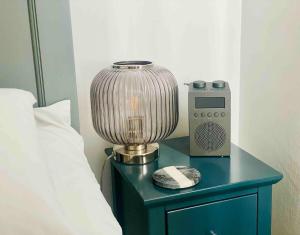 a bedside table with a lamp and a radio on it at Spacious City Centre Apartment Bath in Bath