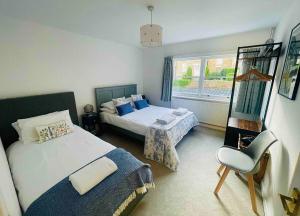 - une chambre avec deux lits, une chaise et une fenêtre dans l'établissement Spacious City Centre Apartment Bath, à Bath
