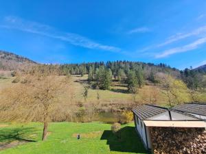 une maison dans un champ avec une montagne en arrière-plan dans l'établissement Tariche Centre de Vacances, à Saint-Ursanne