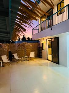 a patio with chairs and a table and a building at Caleo Boracay Island Station 3 in Boracay