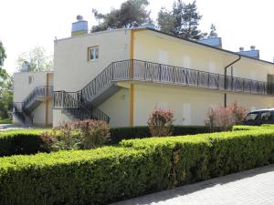 a building with stairs and bushes in front of it at Ośrodek Wczasowy Akacja in Dźwirzyno