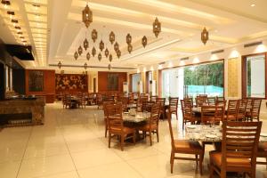 a restaurant with tables and chairs in a room at Hotel Chandela Khajuraho in Khajurāho