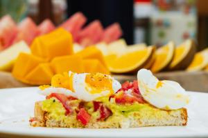 a piece of toast with eggs on top on a plate at Karibu Africa Home in Moshi