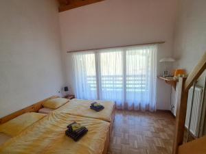 1 dormitorio con 2 camas y ventana grande en Tariche Centre de Vacances, en Saint-Ursanne