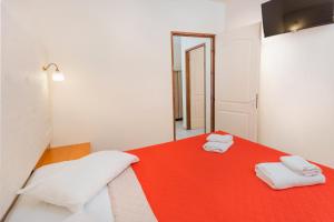 a room with a red bed with two towels on it at Eri Beach & Village Hotel in Hersonissos