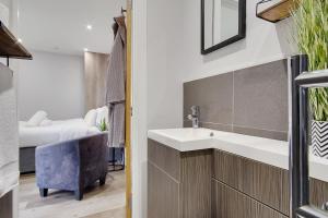 a bathroom with a sink and a bedroom at Little Paddock in Ringwood