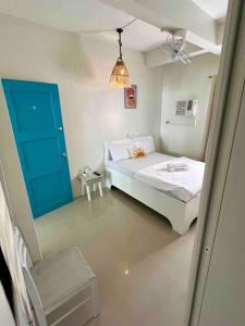 a small bedroom with a bed and a blue door at Caleo Boracay Island Station 3 in Boracay