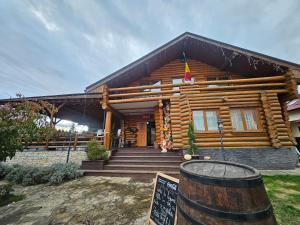 a log cabin with a sign in front of it at Domeniul Haiducilor Bucovina in Suceava