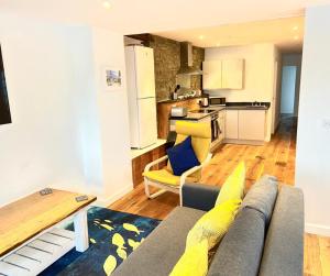 Il comprend un salon avec un canapé et une cuisine. dans l'établissement Harbour Lights Apartment New Quay, à New Quay