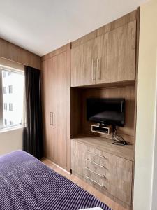 1 dormitorio con 1 cama, TV y armarios en LK Barro Preto 9, en Belo Horizonte